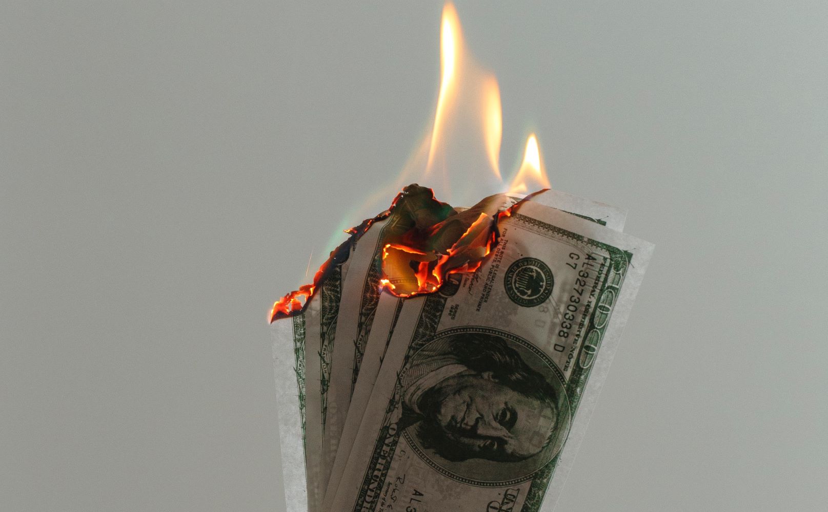 financial toxicity burning money fire