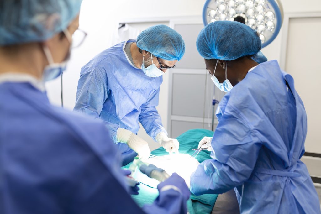 Surgeon team in uniform performs an operation on a patient